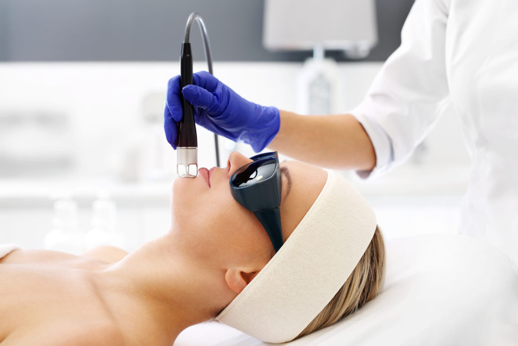 Woman getting laser hair removal on the face.